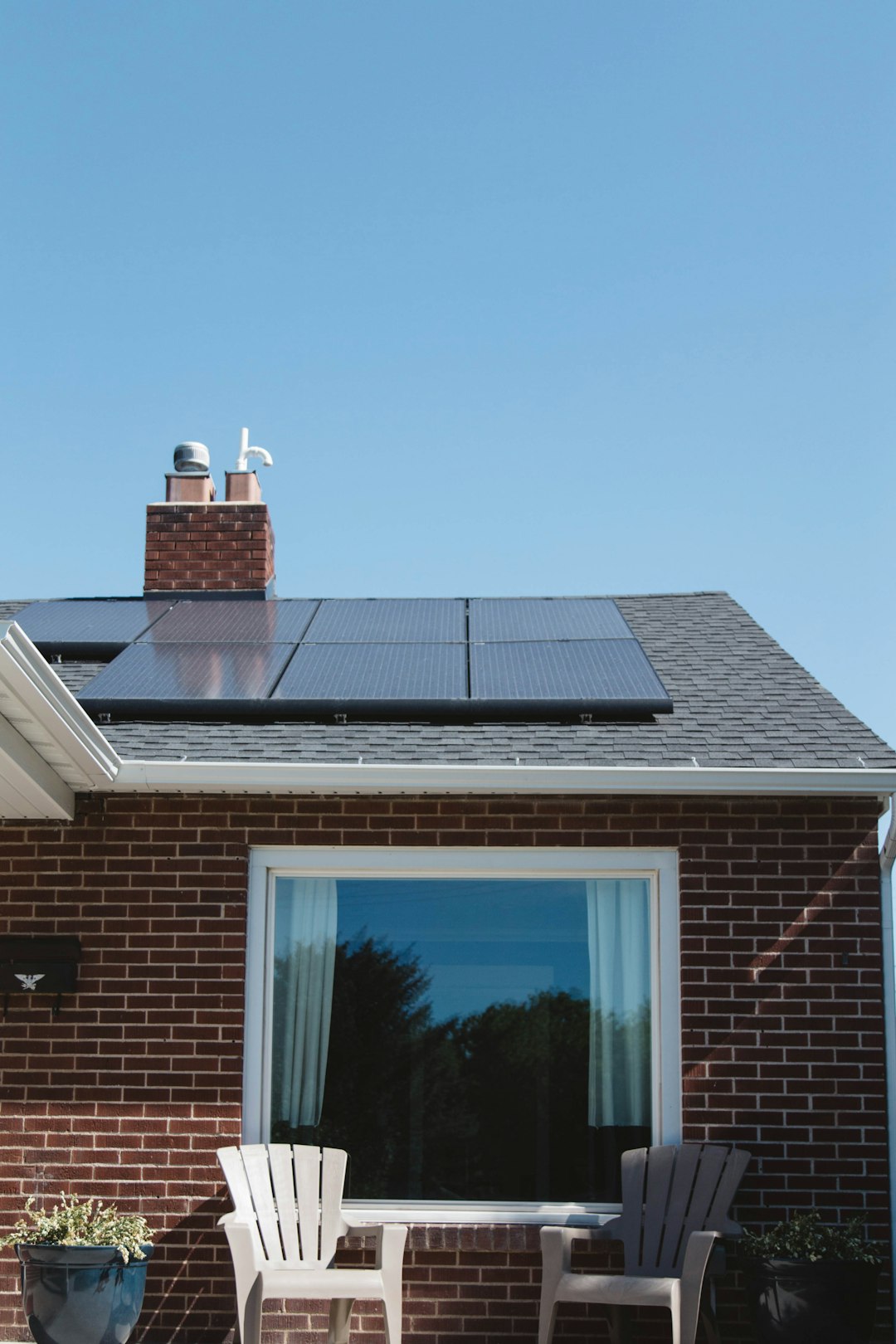 The Art of Drawing Readers In: Your attractive post title goes here Vivint Solar - Solar Panels on roof of brick home with window and Adirondack chairs.